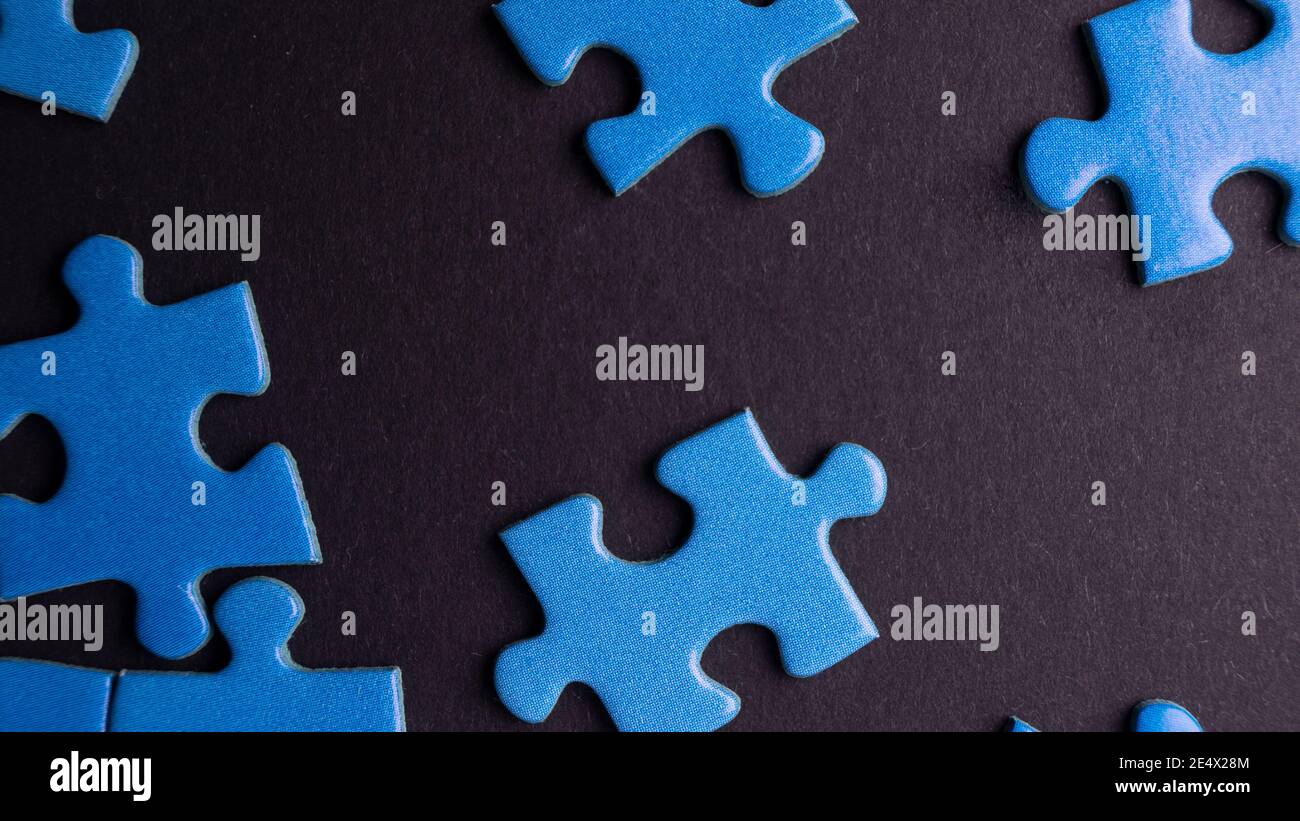 scattered puzzle pieces on colored background Stock Photo