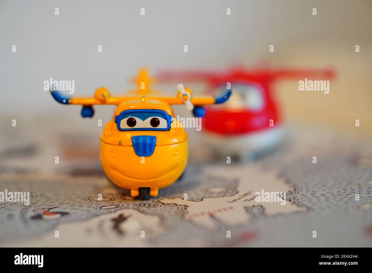 POZNAN, POLAND - Jan 24, 2021: Jett and Donnie Super Wings action figures on a opened book with map in soft focus background. Stock Photo