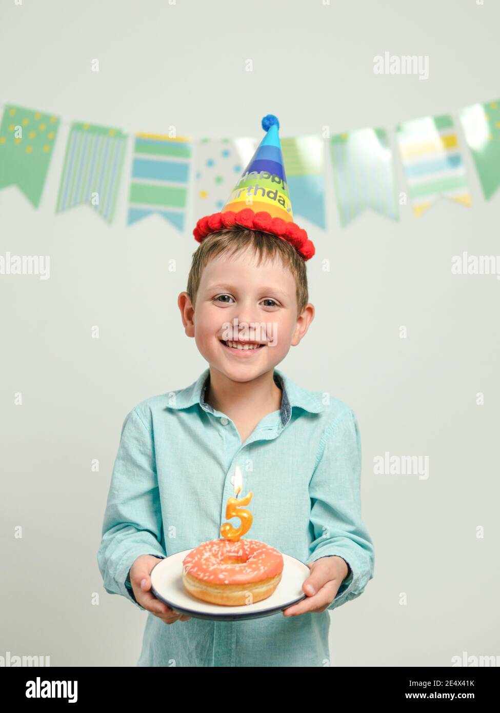 Five year old boy in his birthday with festie donut. Happy little child