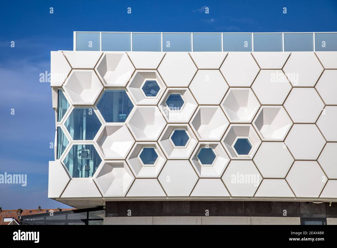 Closeup of modern facade of geometric architecture building in the Netherlands against blue sky. Stock Photo