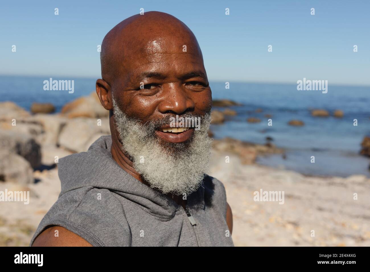 Portrait of fit senior african american man by the sea smiling. healthy retirement outdoor fitness lifestyle. Stock Photo