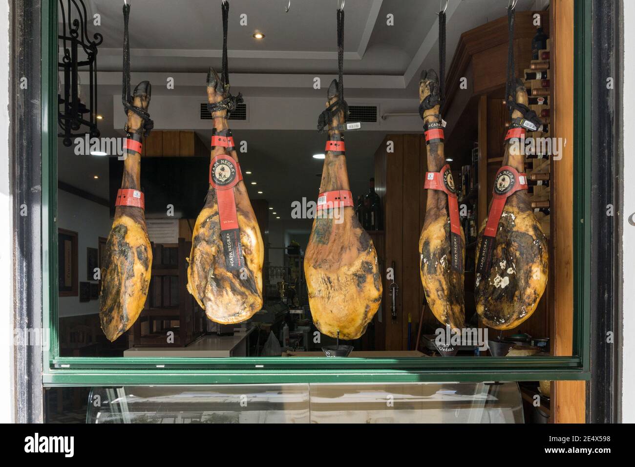 Spanish hams hanging in an open cafe window, Cadiz, Spain Stock Photo