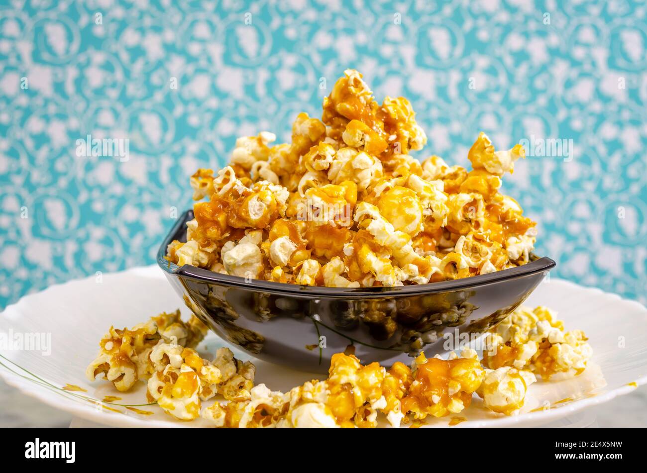 Mound of Sweet Caramel Popcorn in a black bowl. Stock Photo