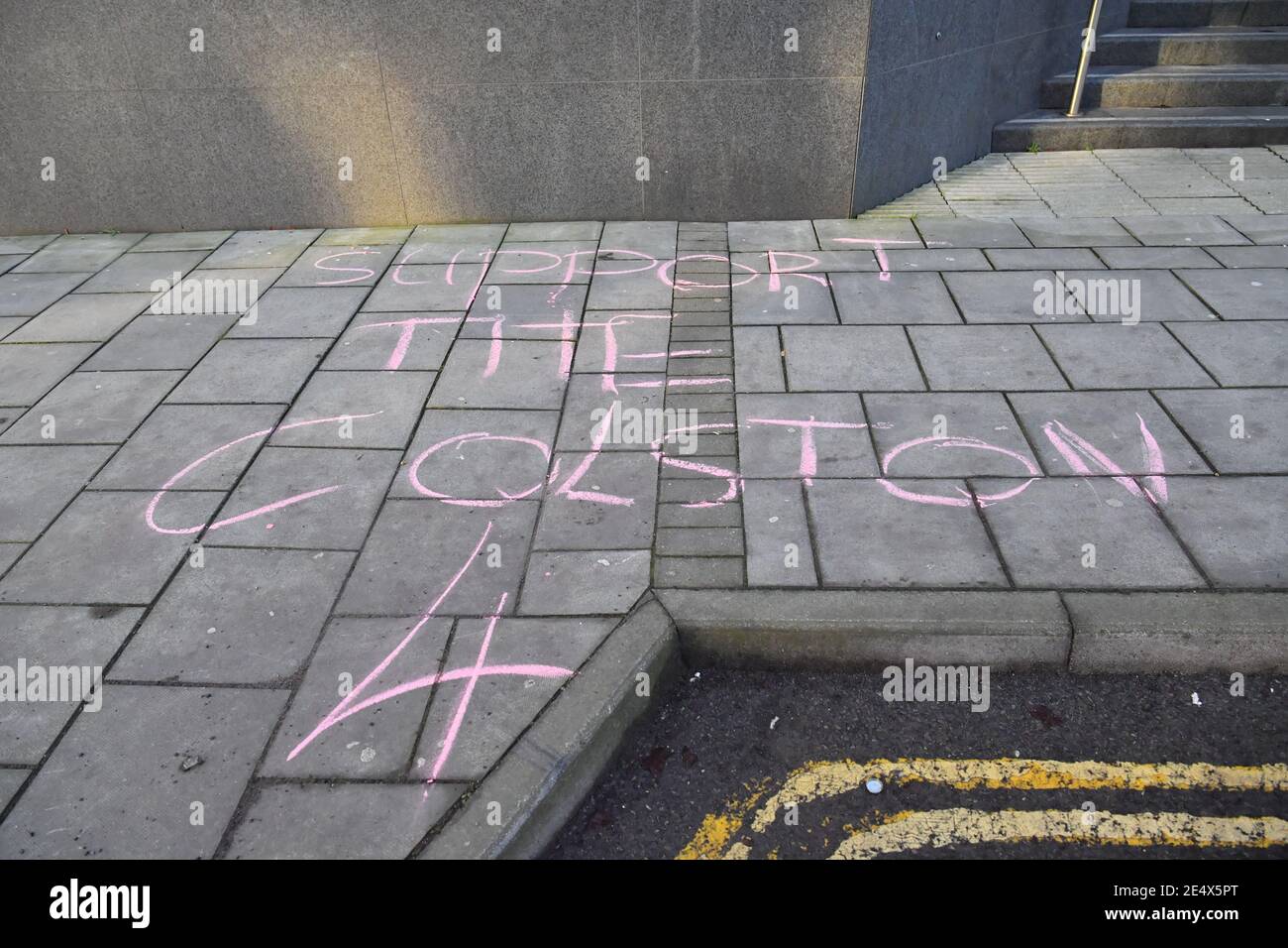 A woman writes 'Support the Colston 4' in chalk outside Bristol Magistrates' Court, where Rhian Graham, Milo Ponsford, Jake Skuse and Sage Willoughby are due to appear charged with criminal damage over the toppling of the Edward Colston statue in Bristol during the Black Lives Matter protests in June last year. Picture date: Monday January 25, 2021. Stock Photo