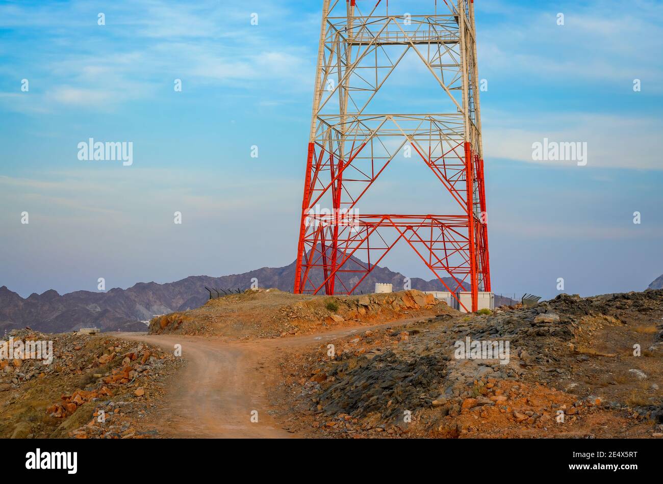 Dirt Road near a red & white Mobile Tower on a hilltop. From Muscat, Oman. Stock Photo