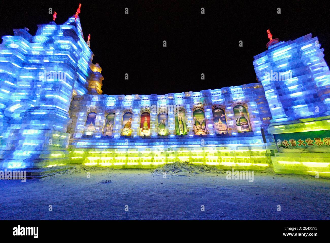 HARBIN,CHINA-JANUARY 30, 2010: lluminated fortification wall carved in ice with advertisement for beer at Harbin Ice & Snow World Festival Stock Photo