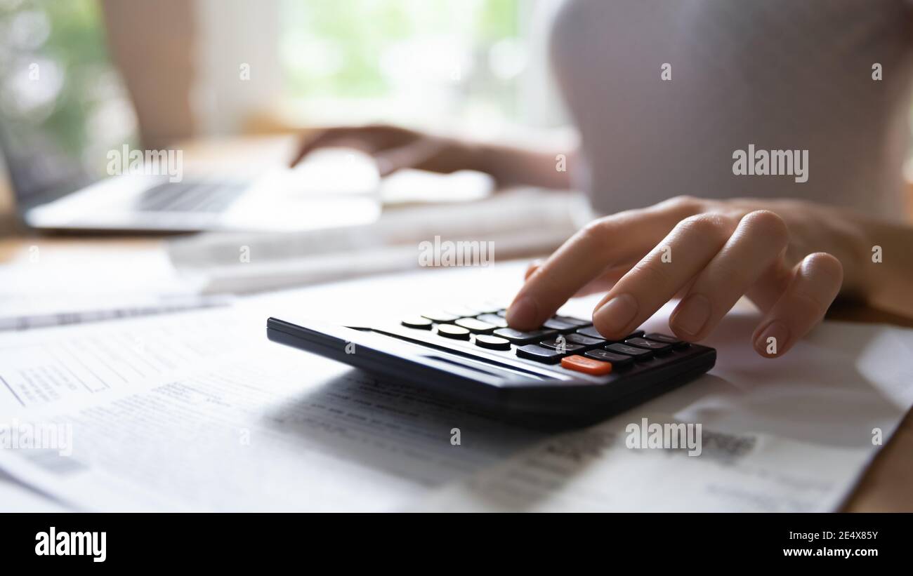 Young female hand counting on electronic calculator planning family budget Stock Photo