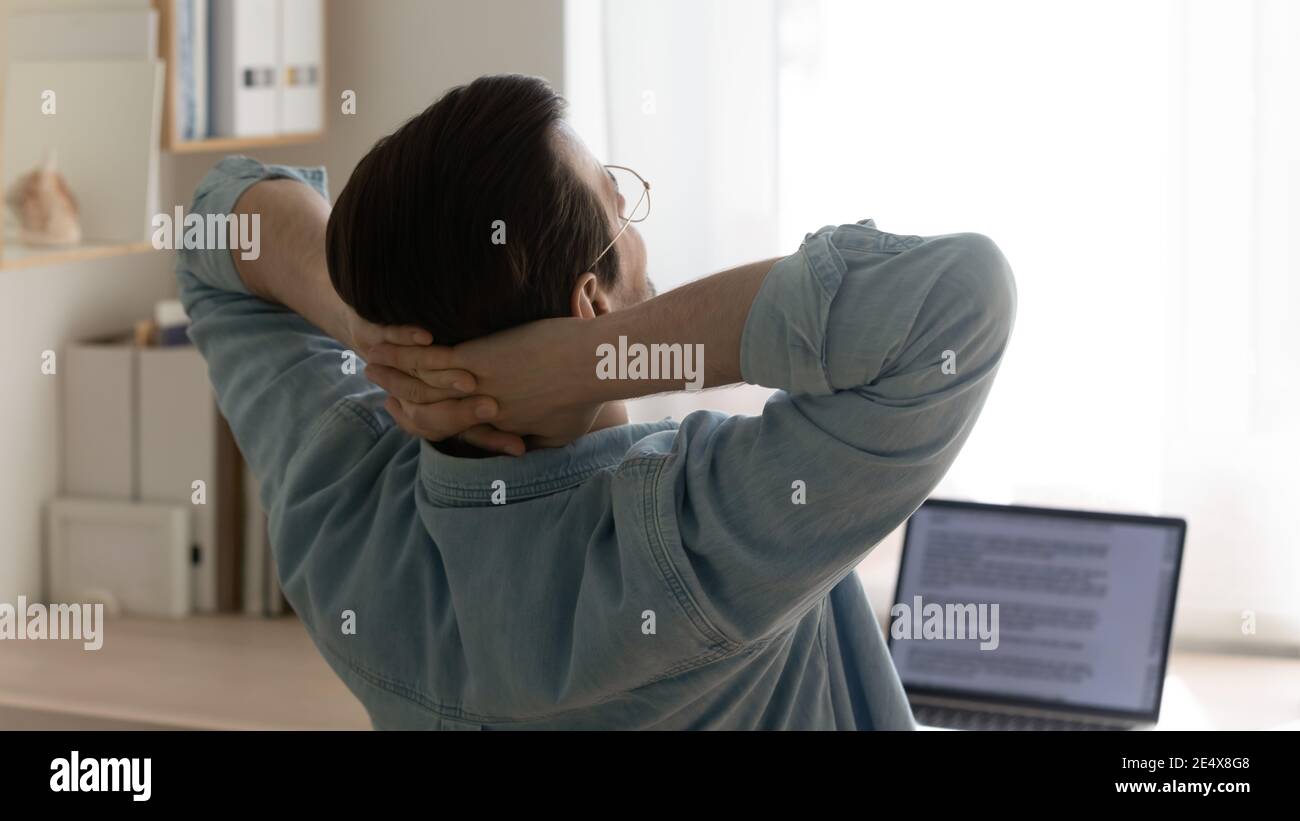 Young man freelancer taking short break of routine computer work Stock Photo