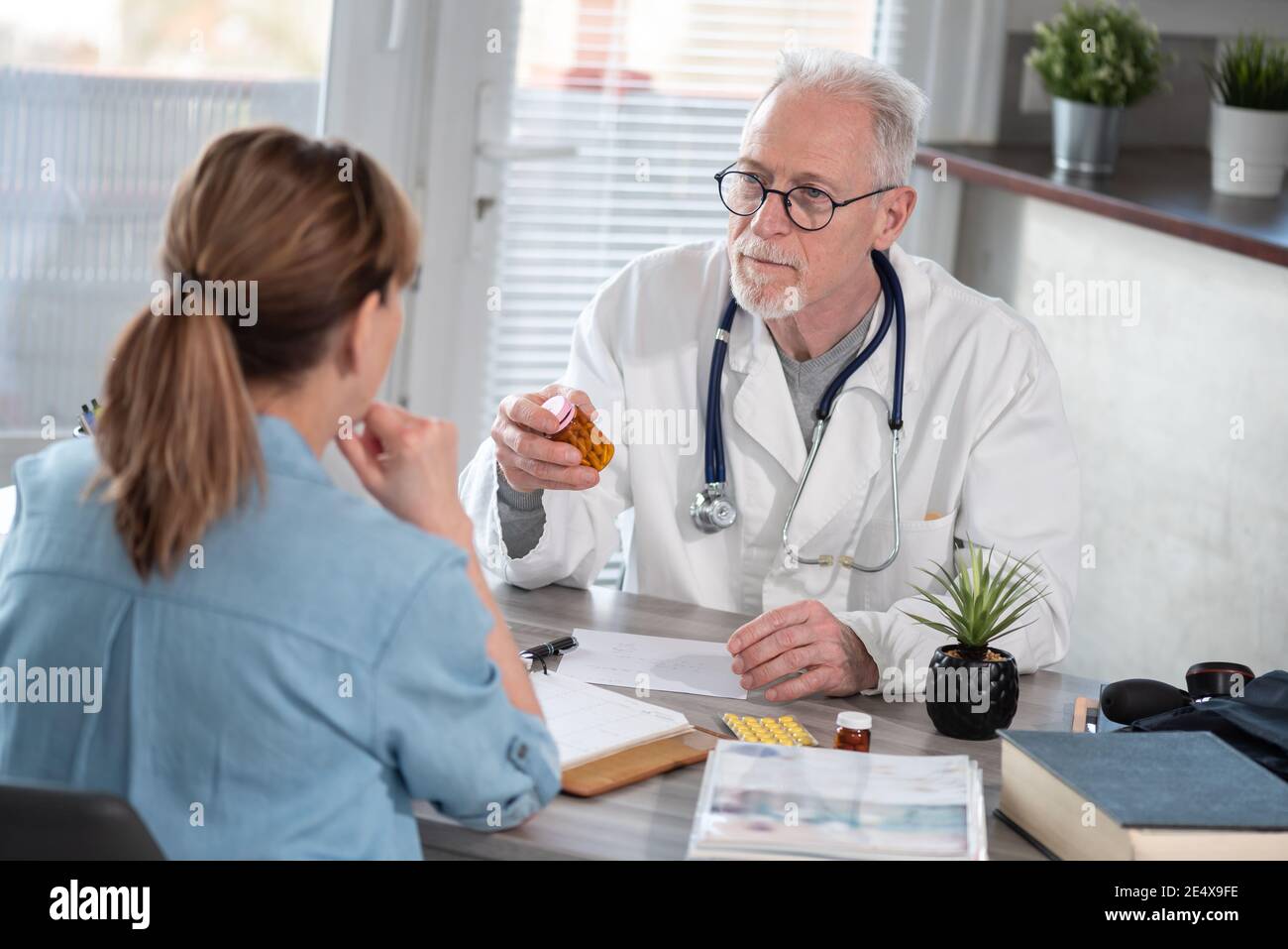 Senior doctor having a discussion with his female patient in medical ...