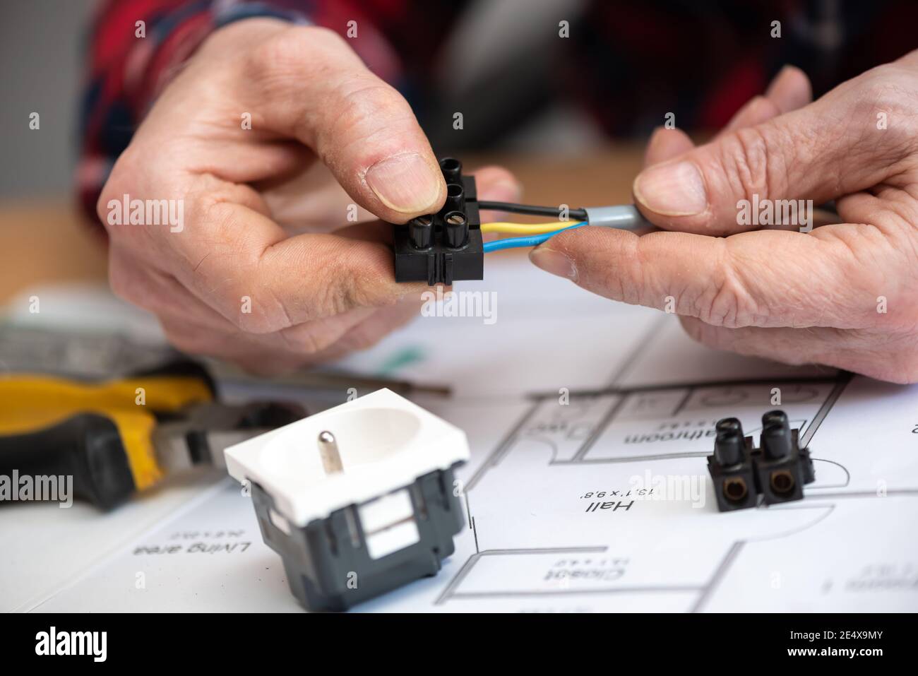 Electrician hands connecting wires in terminal block Stock Photo