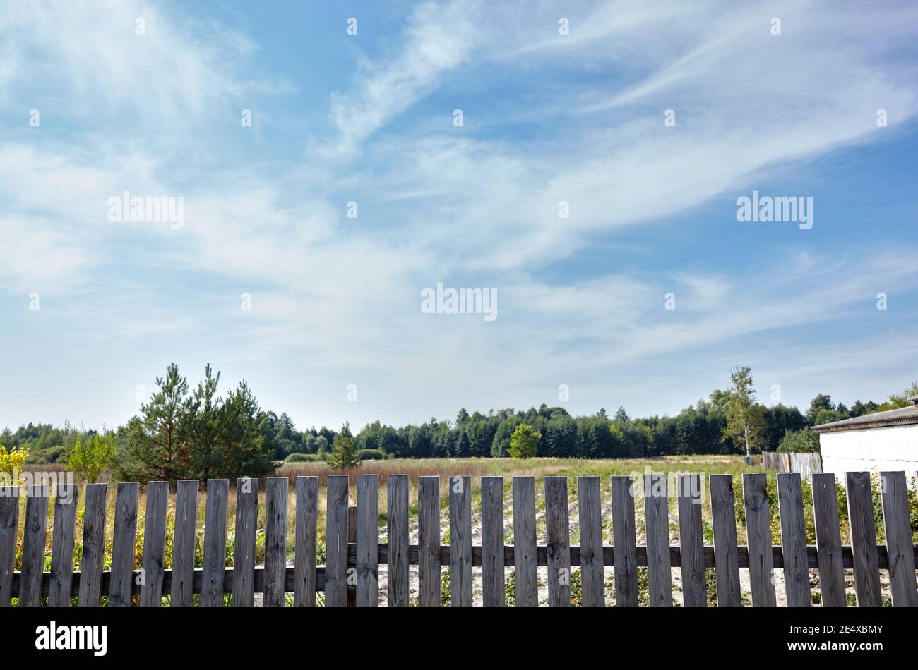 Old wooden fence against a blue sky with clouds on a sunny day ...