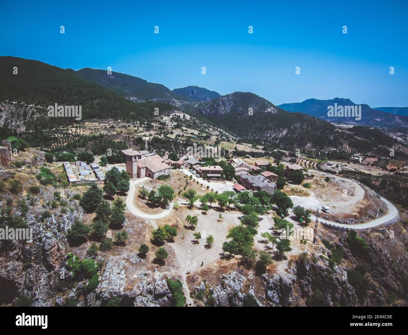 Aerial view of buildings surrounded by green forest hills Stock Photo ...