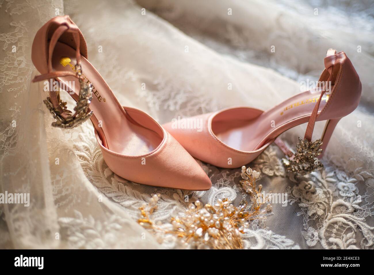 KITCHENER, CANADA - Aug 08, 2019: Beautiful Soft pink heels laying on top  of a white wedding dress, with bride and groom rings Stock Photo - Alamy