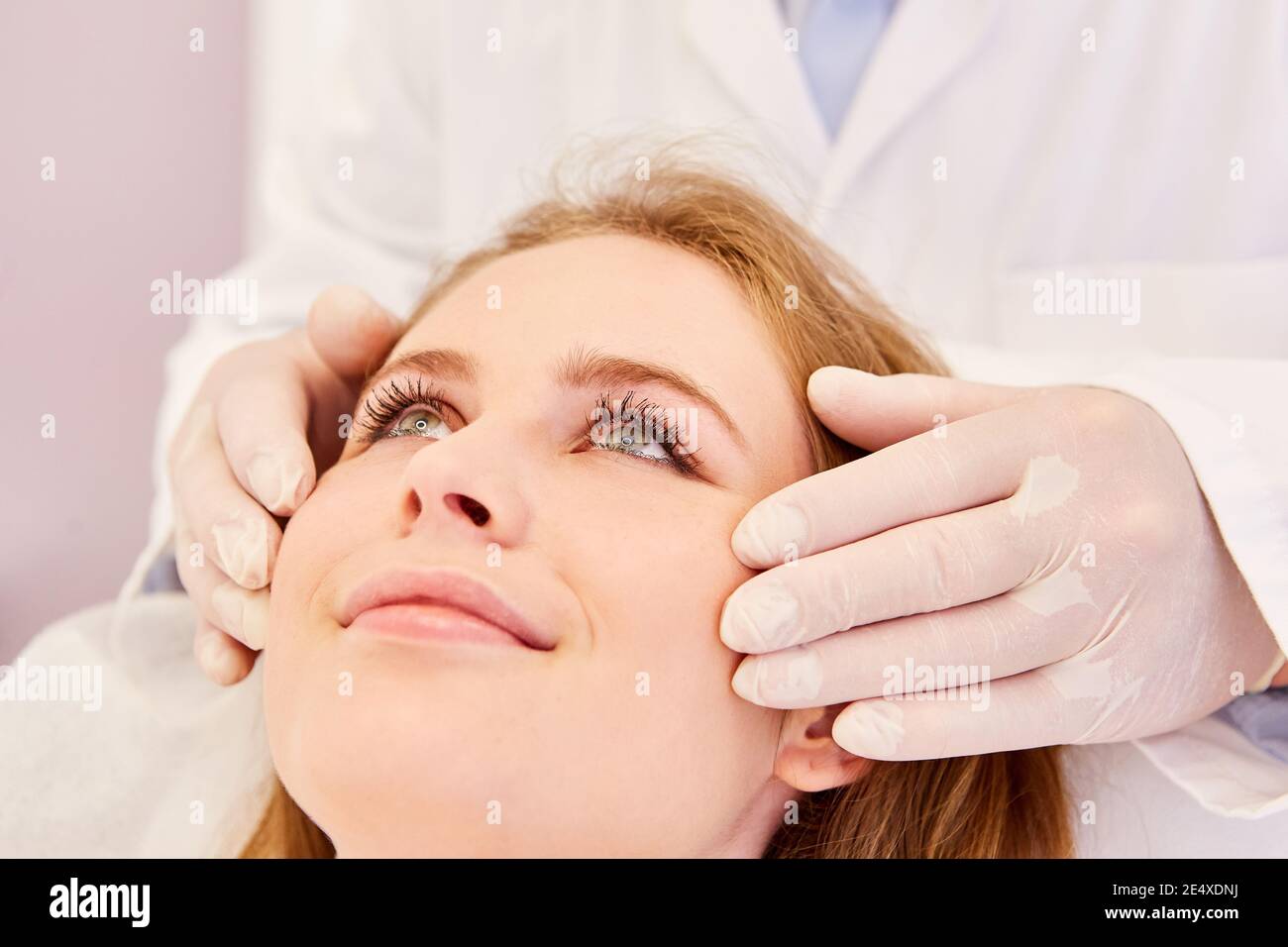 Beautician massages a woman's facial skin for better blood circulation and relaxation Stock Photo