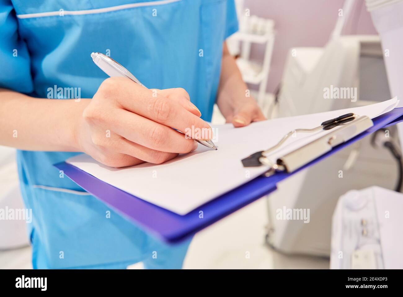 Surgical nurse with checklist for plastic surgery in the cosmetic