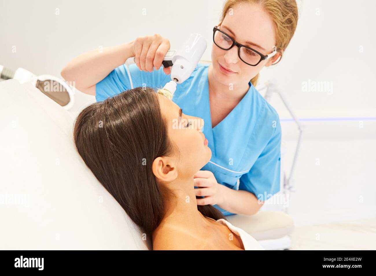 Woman during professional facial cleaning in the cosmetic studio with an electric brush Stock Photo