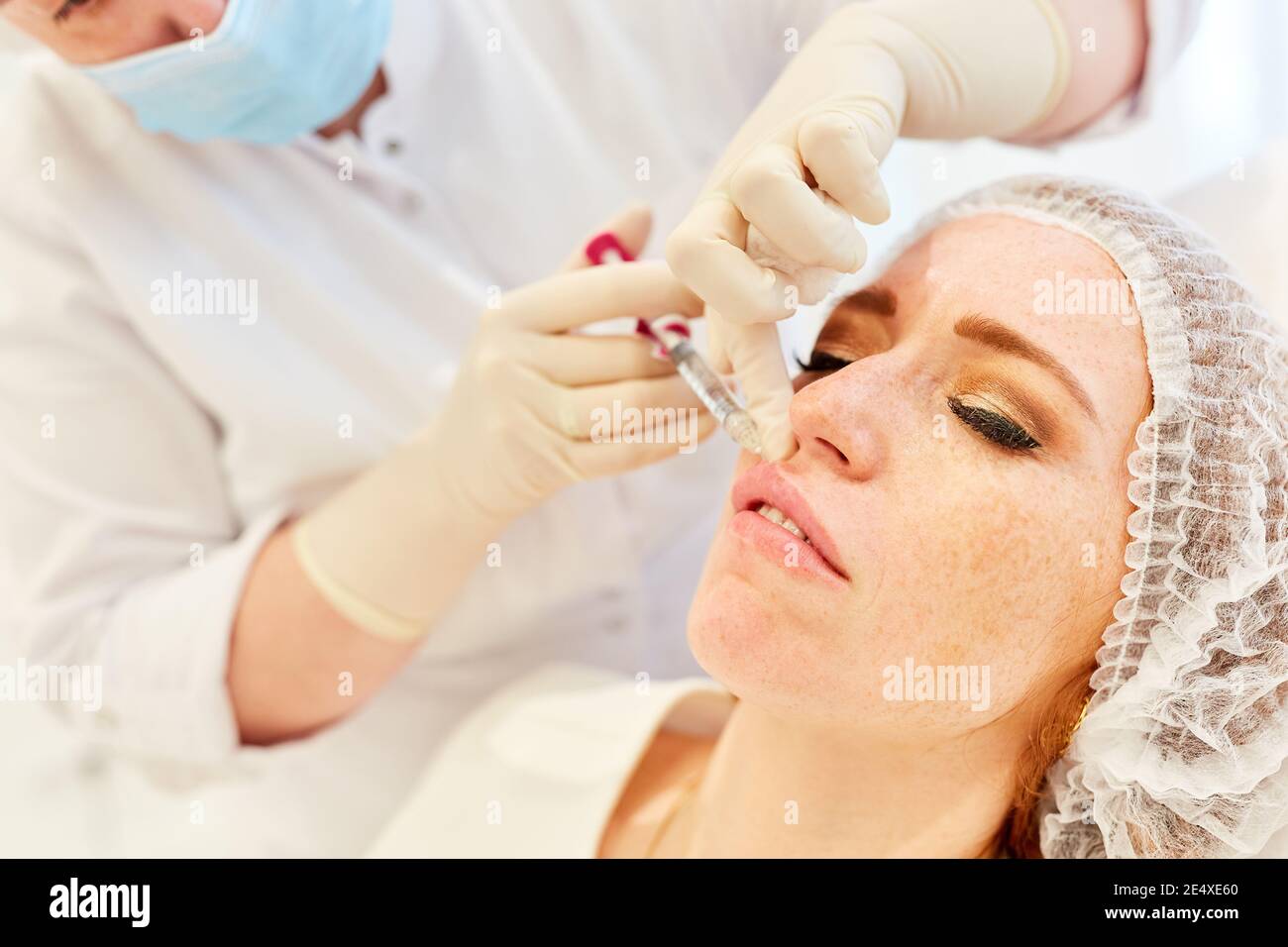 Woman injecting hyaluronic acid on her lips at the plastic surgery specialist Stock Photo