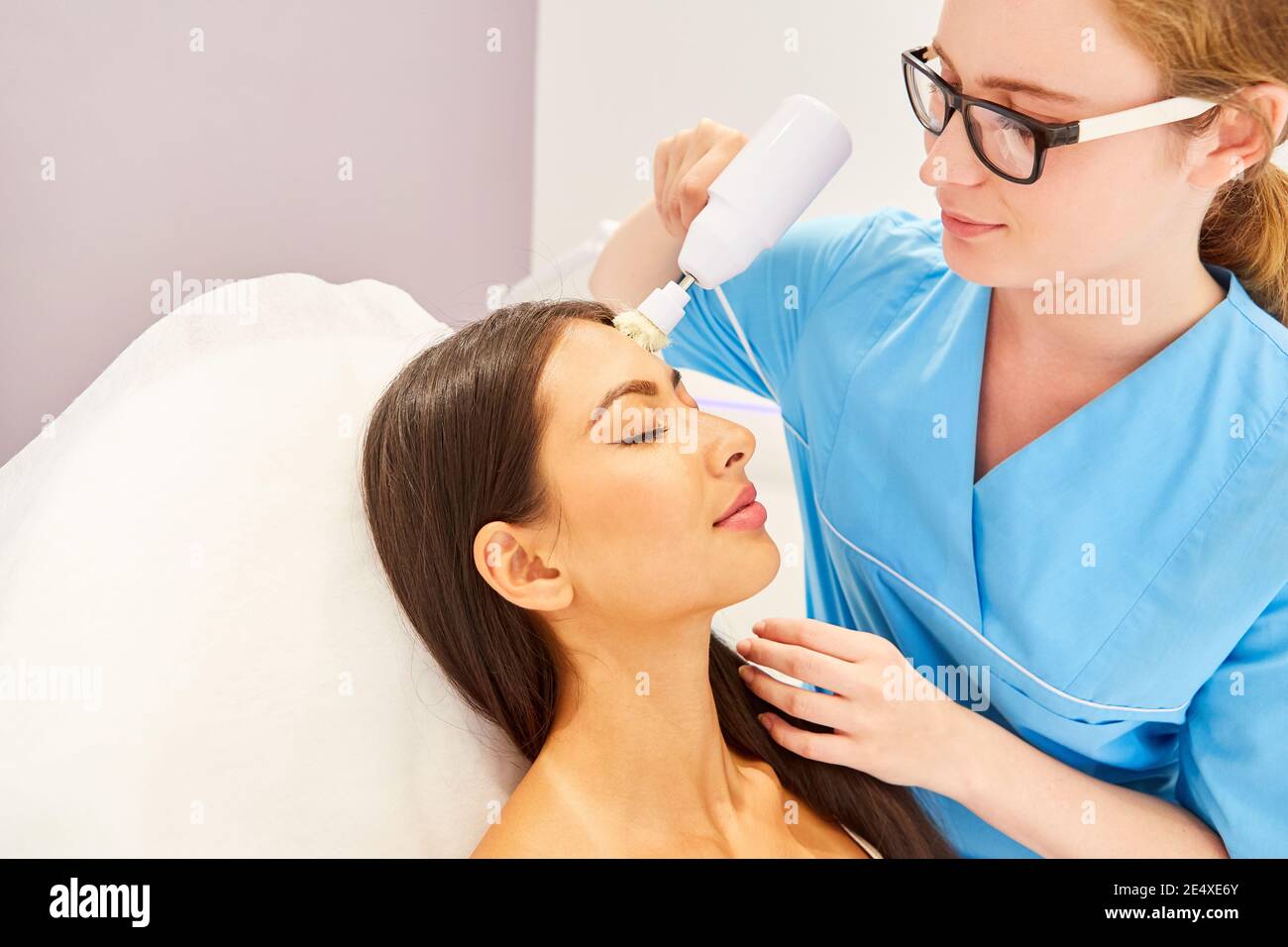 Lymph massage with an electric brush and deep facial cleansing in the cosmetic studio Stock Photo