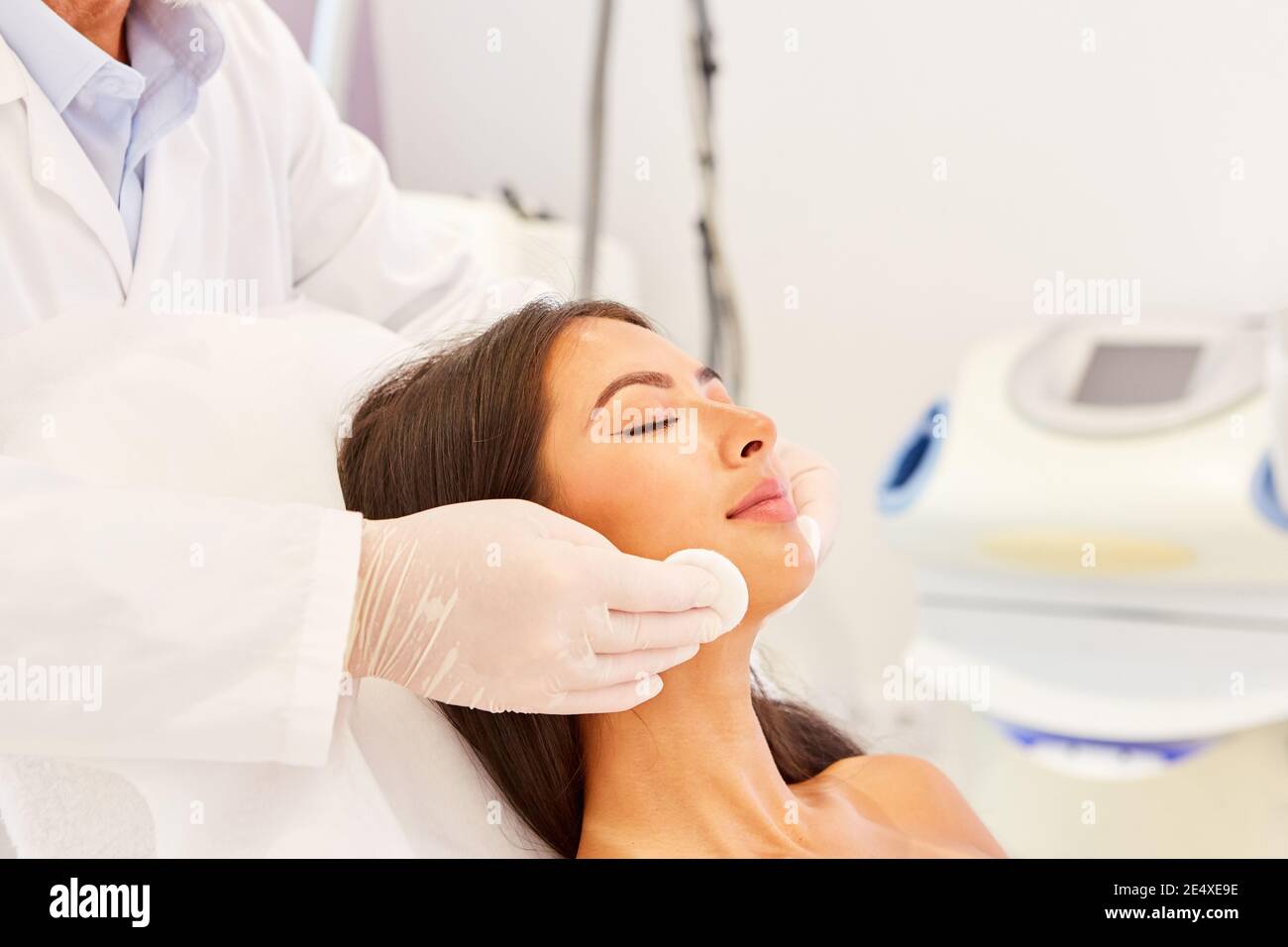 A woman's face is professionally cleaned with cotton pads in the cosmetic studio Stock Photo