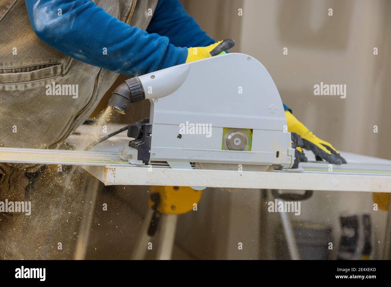 Wood contractor using an electric saw to cut door trim boards in the