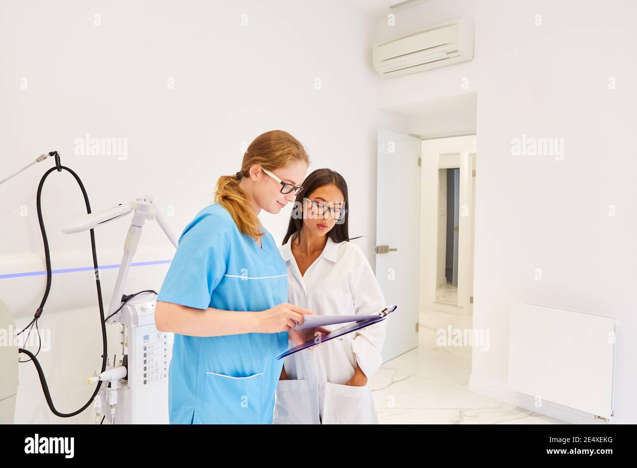 Doctor and OR nurse with clipboard are planning cosmetic surgery Stock Photo