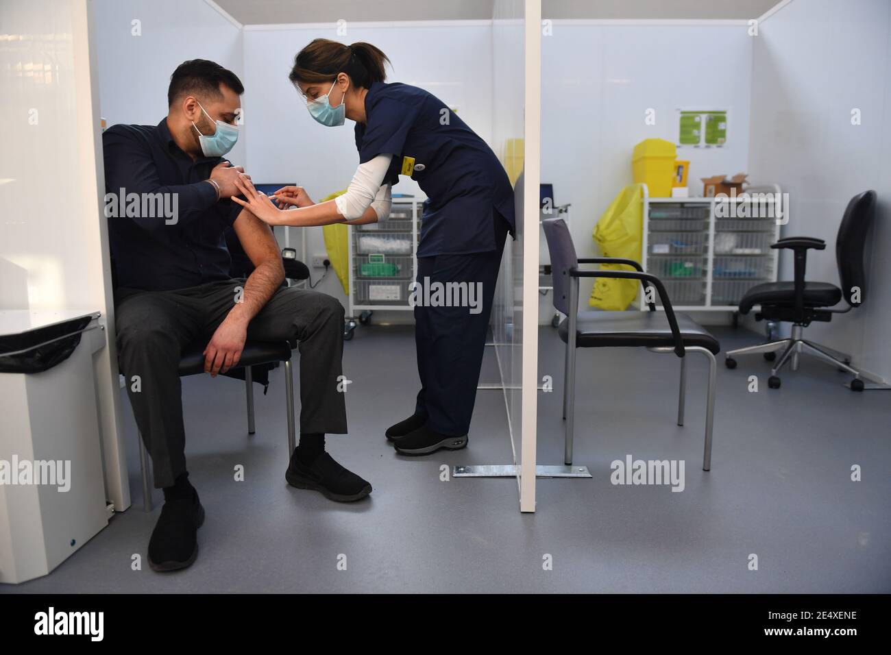 Pharmacist Josh Athwal (left) receives an injection of the Oxford/Astrazeneca coronavirus vaccine, administered by nurse Gurit Dhadday, at The Black Country Living Museum in Dudley. The open air museum, which has previously been used as a set for the BBC drama Peaky Blinders, is now being used as a covid vaccination centre. Picture date: Monday January 25, 2021. Stock Photo