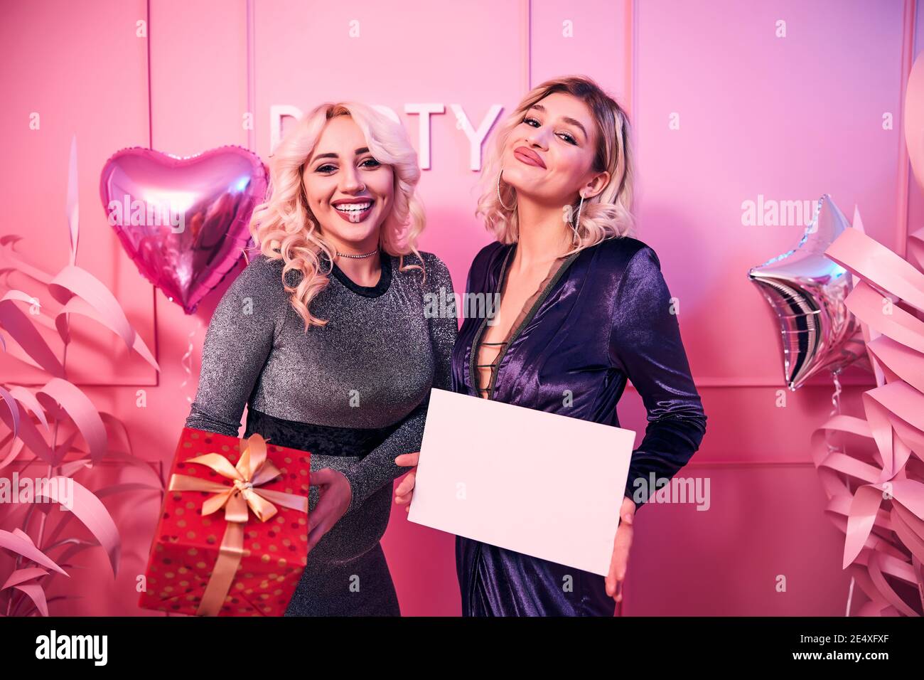 Two happy women with presents looking ahead Stock Photo - Alamy
