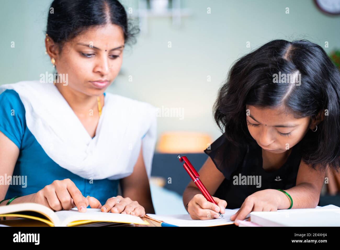 selective focus on kid Mother helping her kid for doing school homework - concept of parenthood, assistance, relationship and bonding Stock Photo