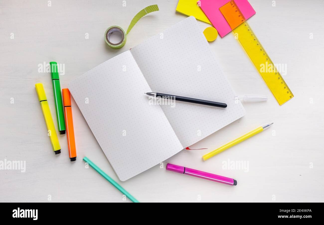 Open pages of planner with dotted pages with a pen, markers, ruler ...