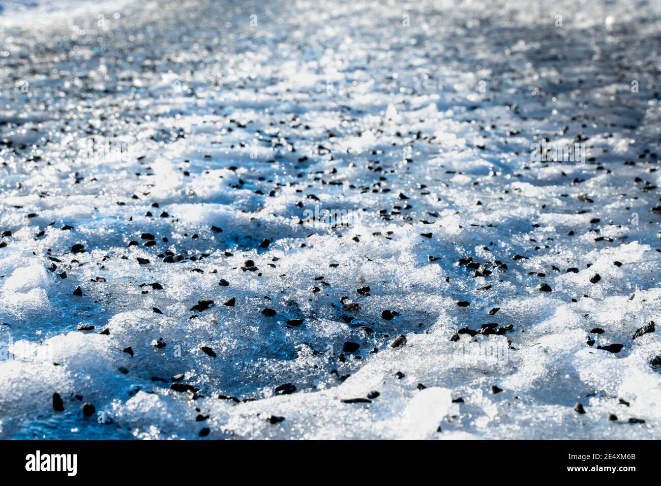 Close up of gravel strewn on an icy road. Stock Photo
