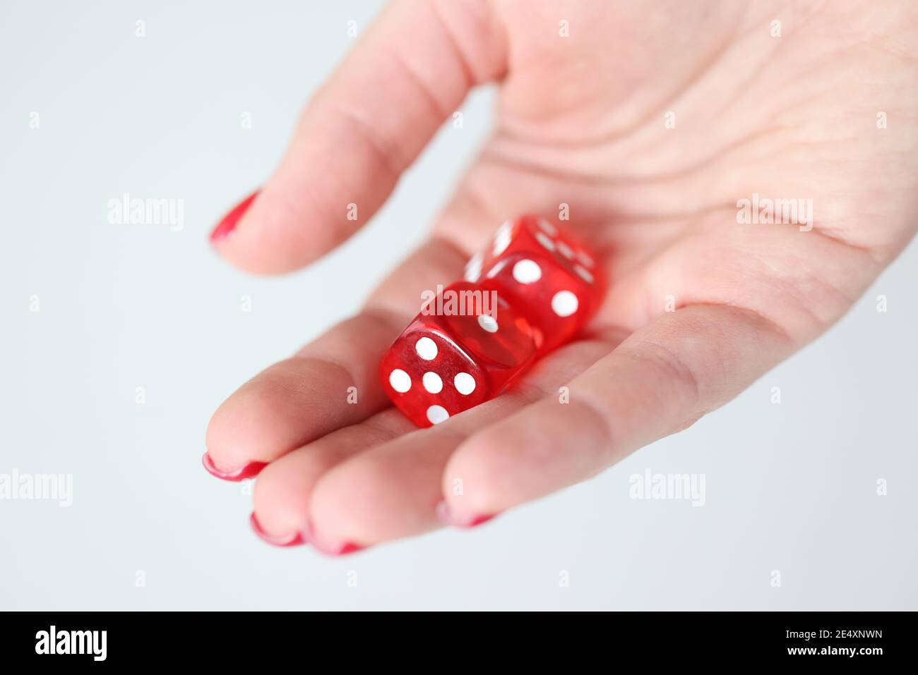 On hand are red dice with white marks Stock Photo