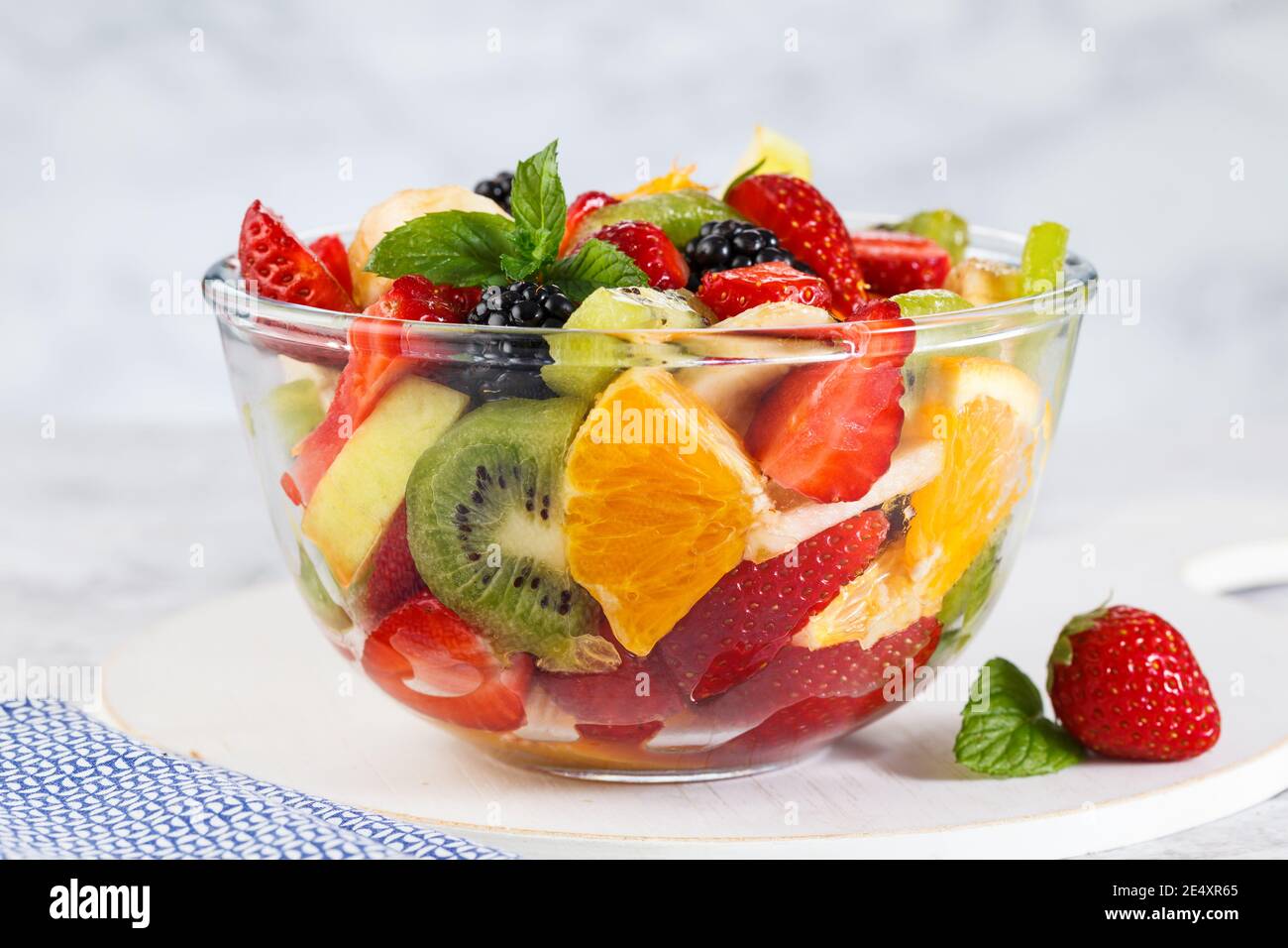 Healthy fresh fruit salad in a bowl on a gray background. Stock Photo