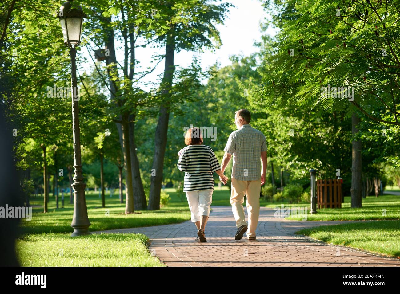 Couple holding hands in the park Stock Photo - Alamy