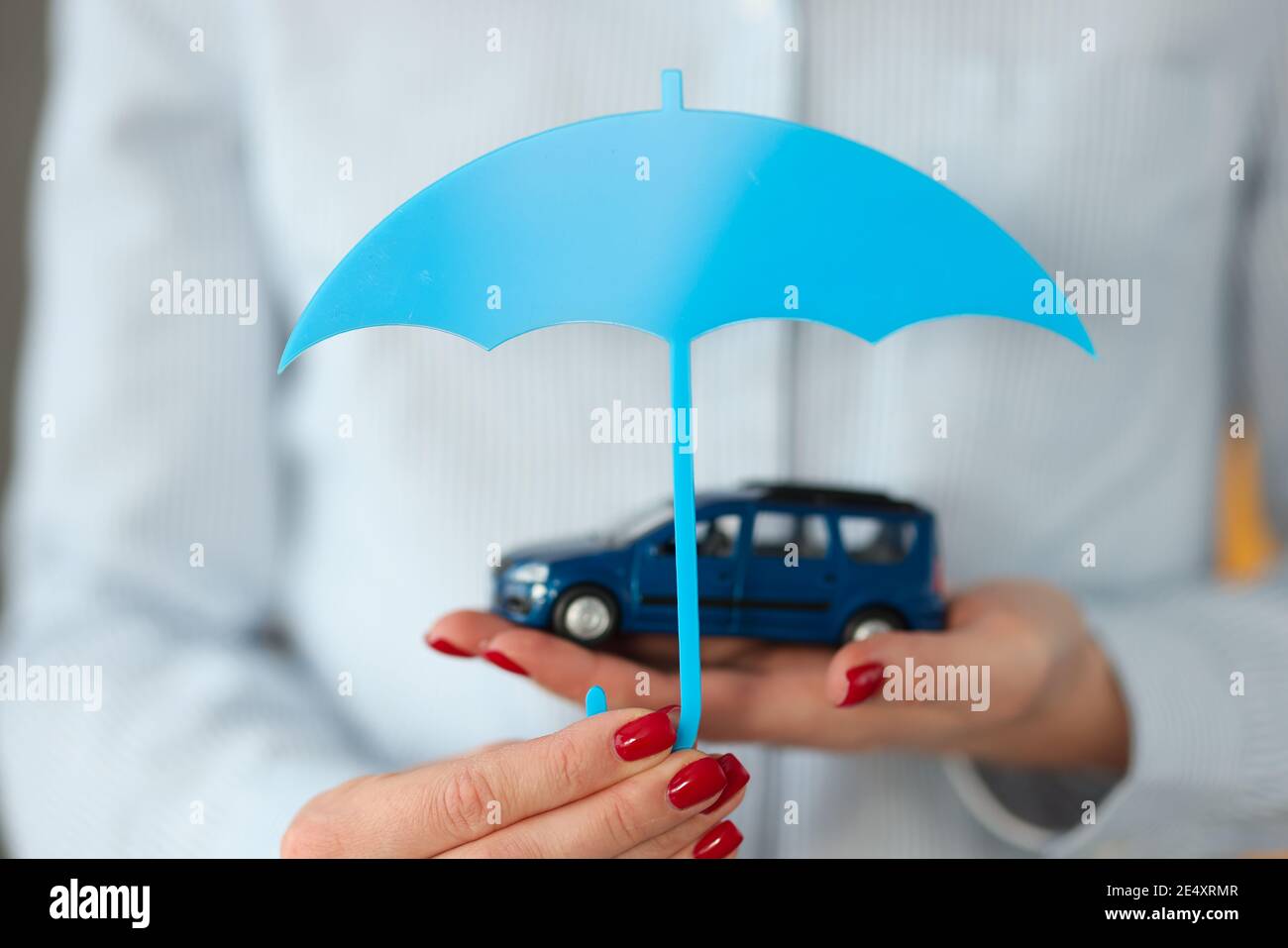 Woman's hand holds car and an umbrella Stock Photo
