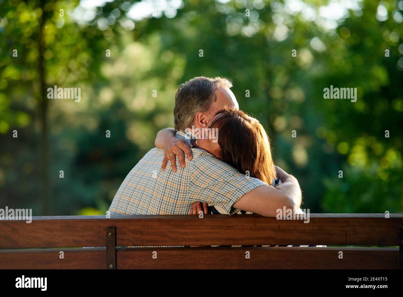 Hugging mature couple on the bench. Stock Photo