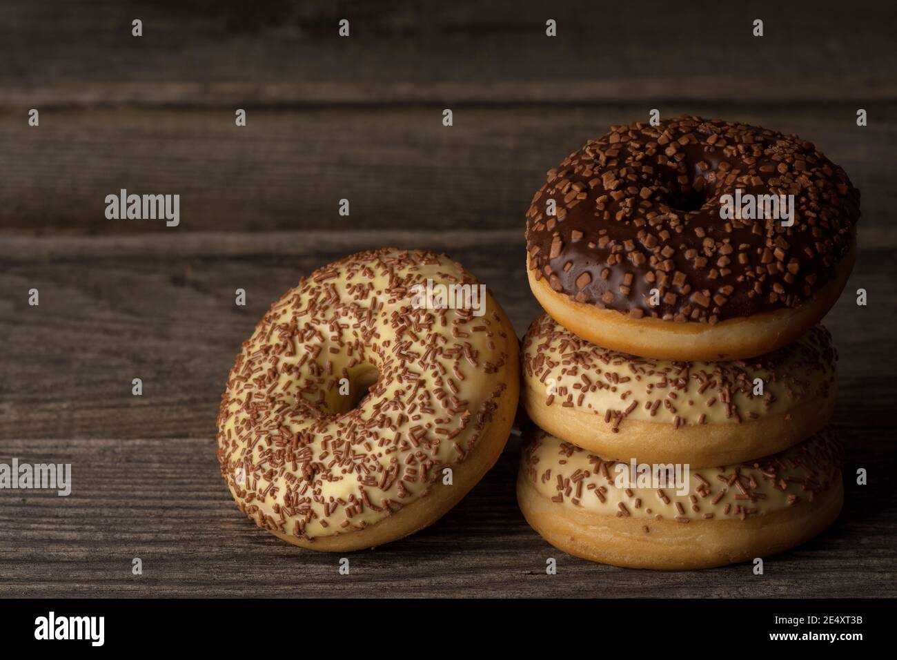 Ring doughnuts covered with vanilla and chocolate glaze, topped with sprinkles. Stock Photo