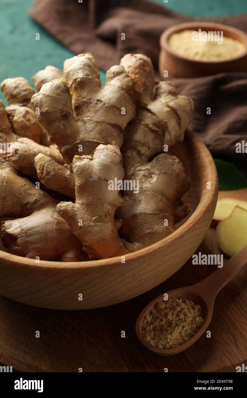 Board with fresh ginger on green background Stock Photo