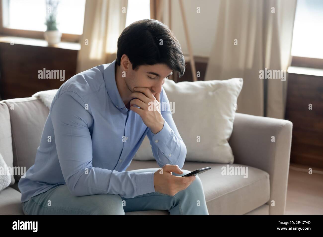 Close up thoughtful serious man using phone, having problem Stock Photo