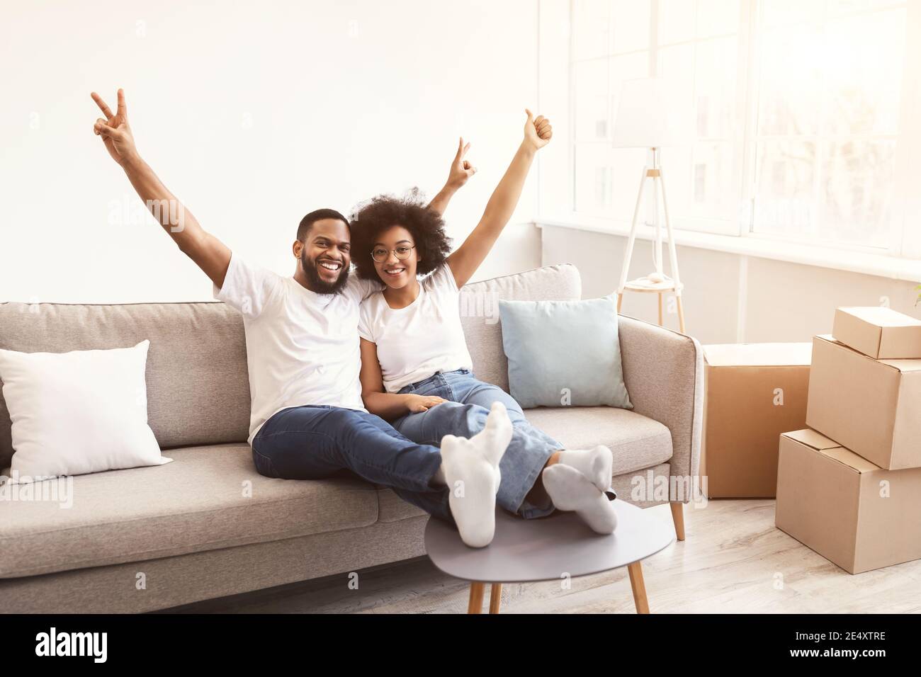 Excited Black Family Couple Celebrating Moving New House Sitting Indoors Stock Photo
