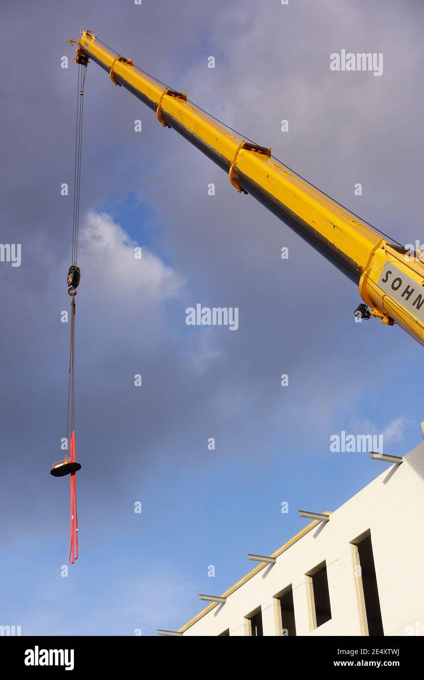 Vertical low angle shot of a tall mobile crane on a construction site ...
