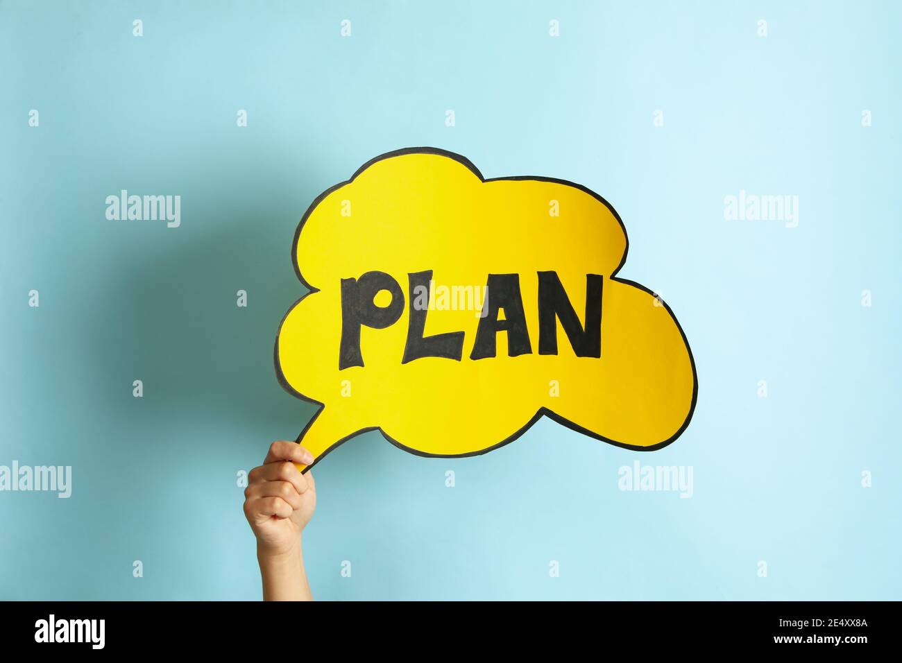 Female hand hold cloud with text Plan on blue background Stock Photo