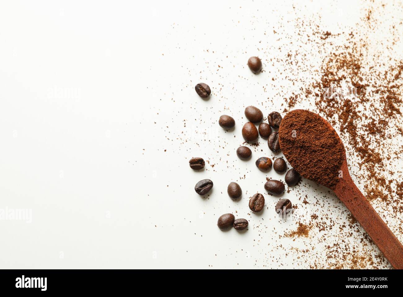 Spoon with ground coffee and beans on white background Stock Photo - Alamy
