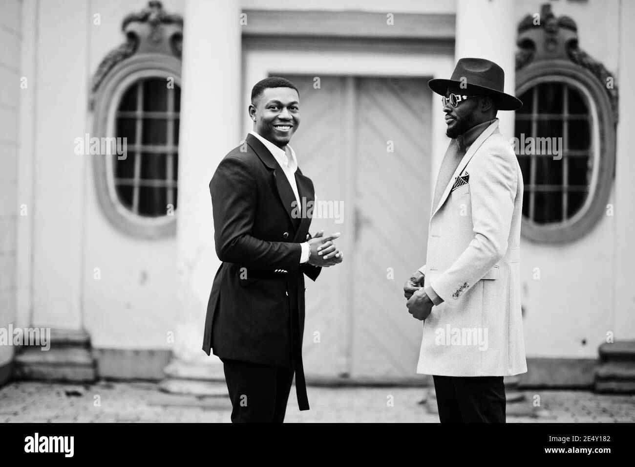 Two fashion black men. Fashionable portrait of african american male models. Wear suit, coat and hat. Stock Photo