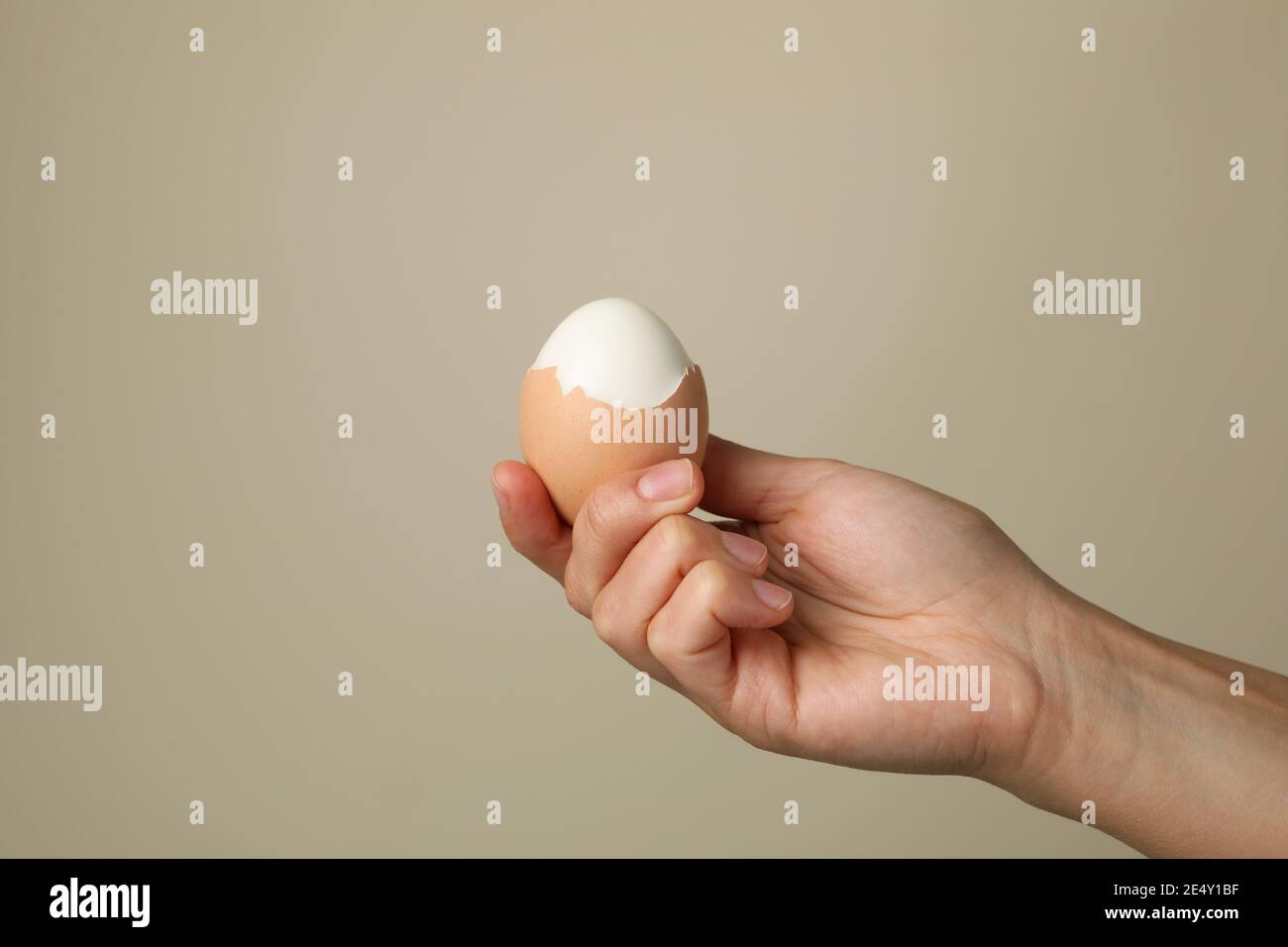 Female hand hold boiled egg on gray background Stock Photo
