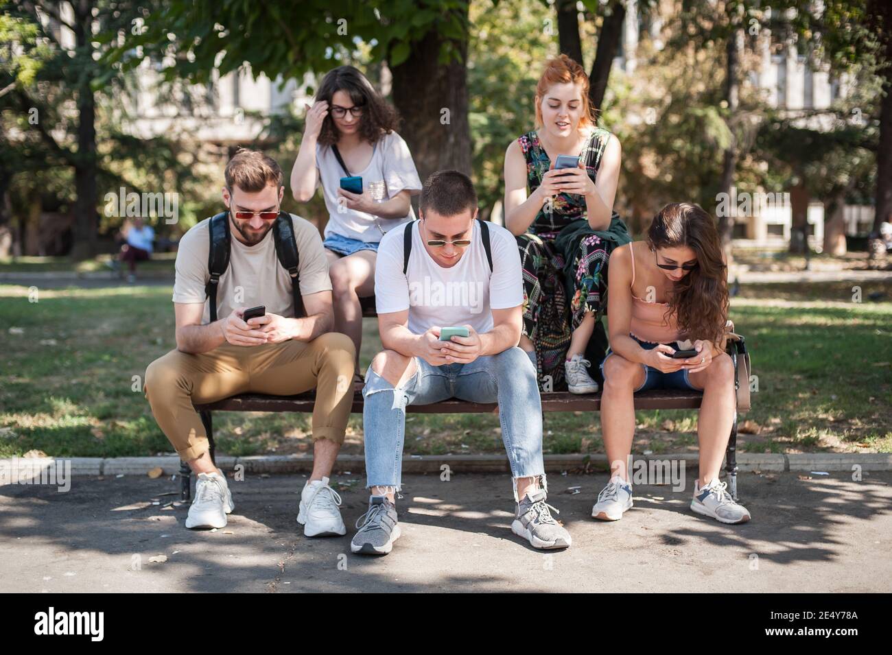 Using Internet With Friends Photo Group of friends using smartphones together. Young people addiction to ...
