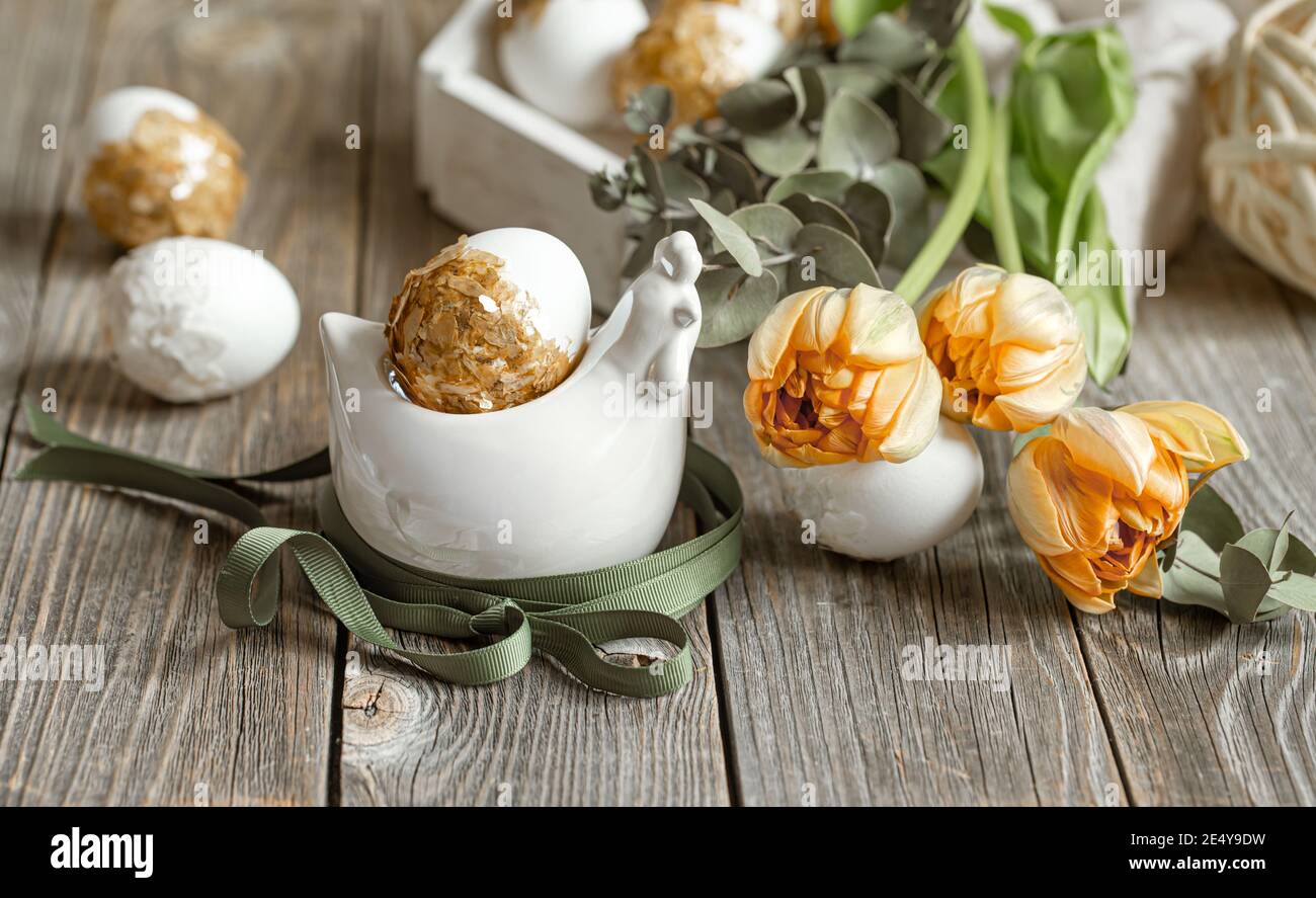Festive composition for the Easter holiday with fresh flowers and eggs. Easter decor concept. Stock Photo