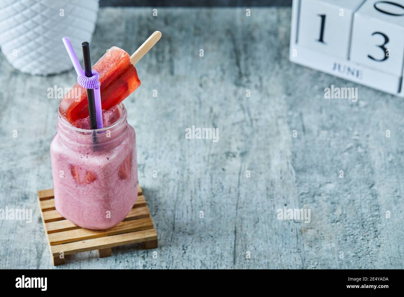 Strawberry milkshake and icecream with straw on the marble background