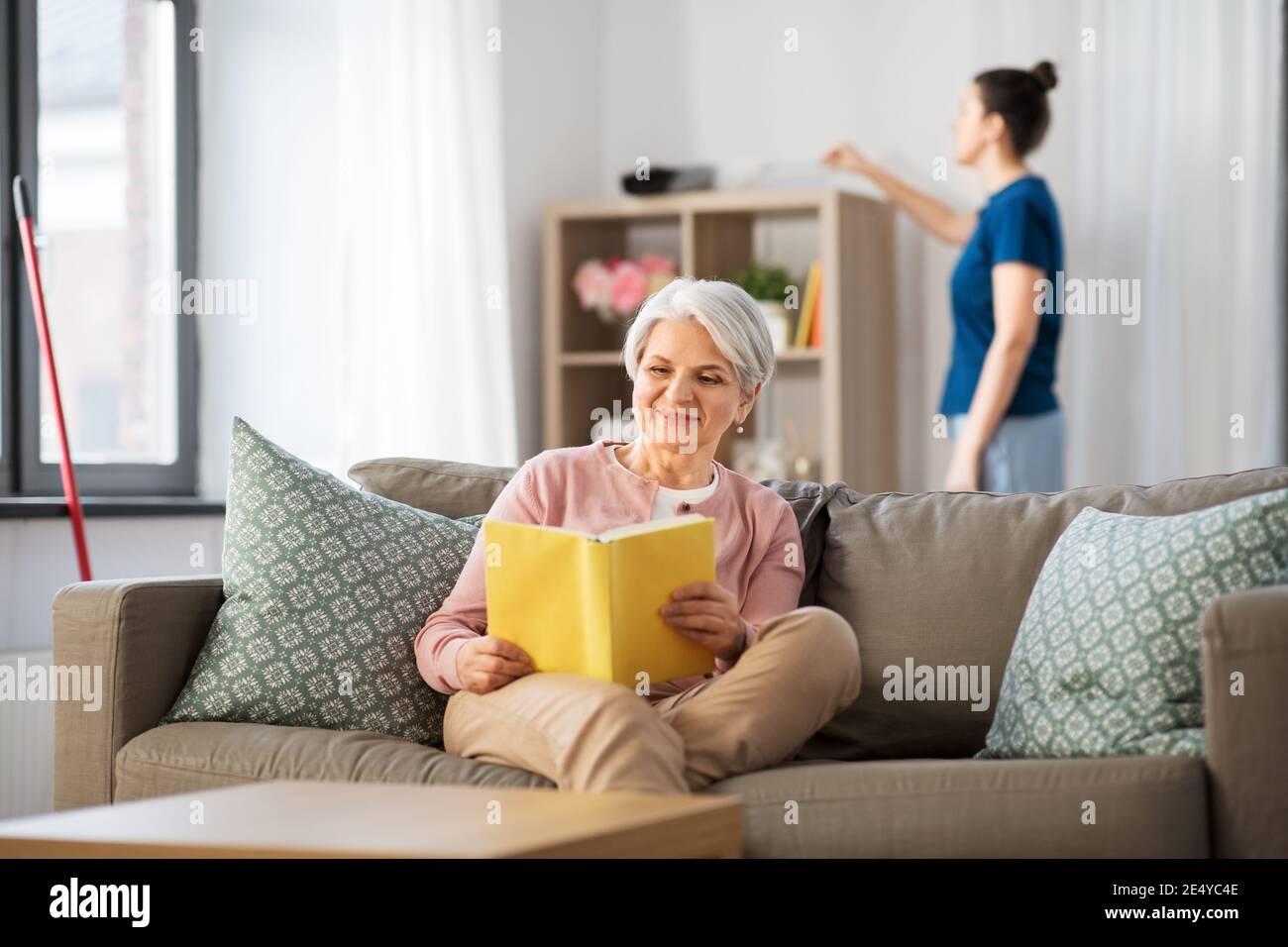 https://c8.alamy.com/comp/2E4YC4E/old-woman-reading-book-and-housekeeper-at-home-2E4YC4E.jpg