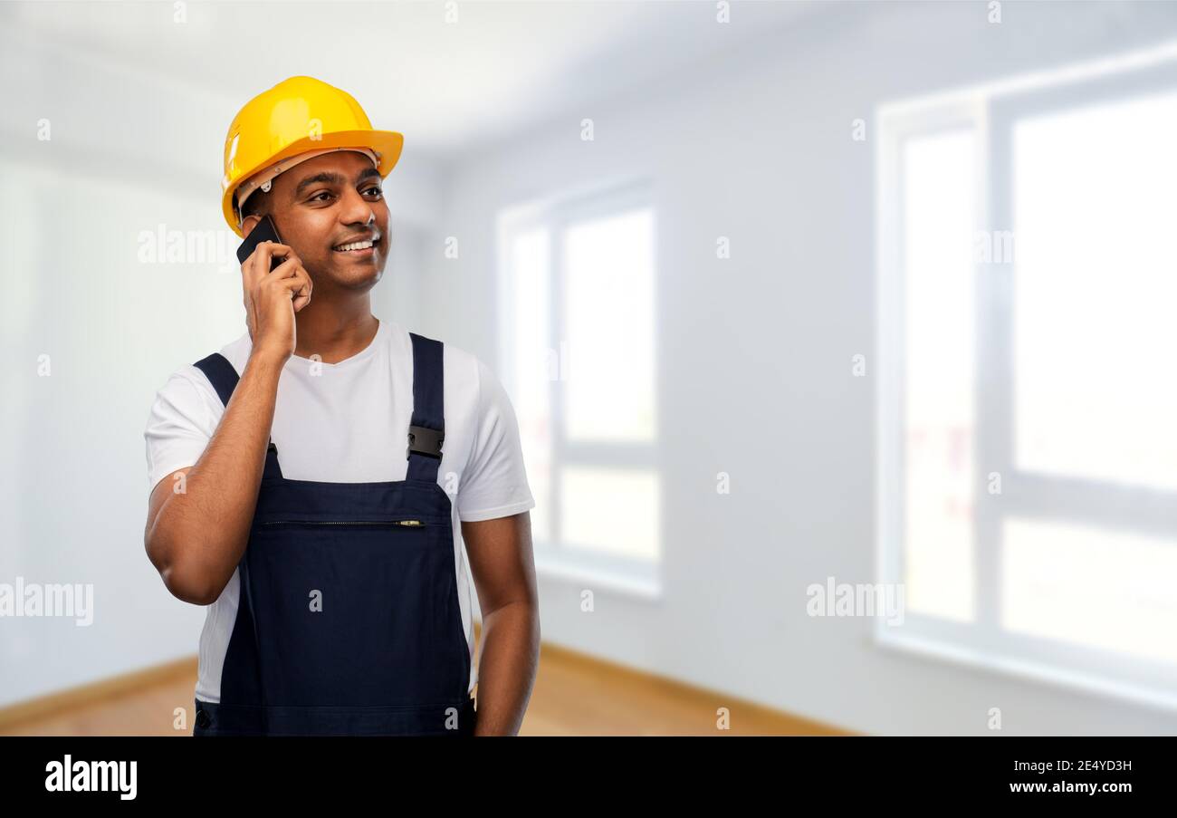 indian builder in helmet calling on smartphone Stock Photo