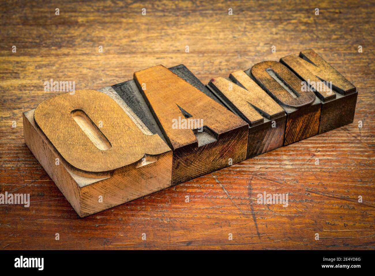 QAnon word abstract in vintage letterpress wood type against rustic wooden background, disproven and discredited far-right conspiracy theory Stock Photo